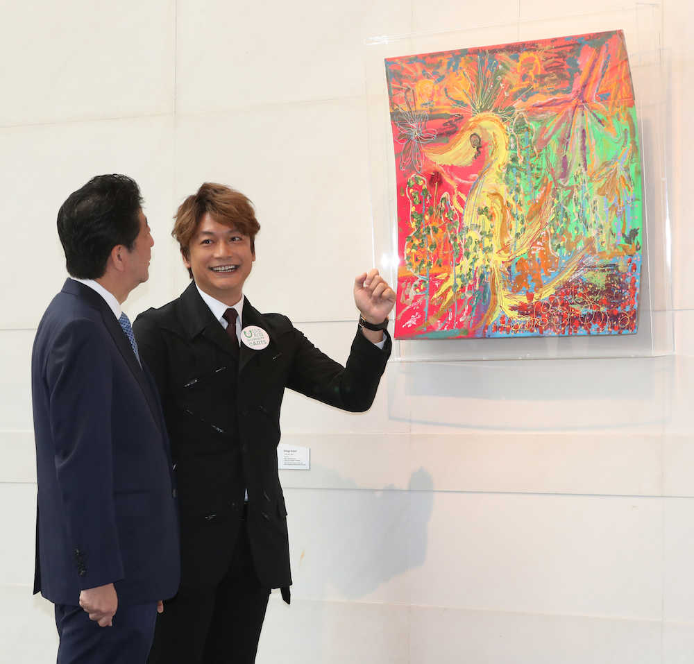 展示された自身の作品を安倍首相（左）に説明する香取慎吾