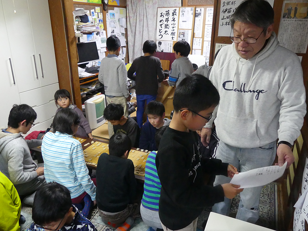 瀬戸市内の「ふみもと子供将棋教室」で指導する文本力雄さん（右）