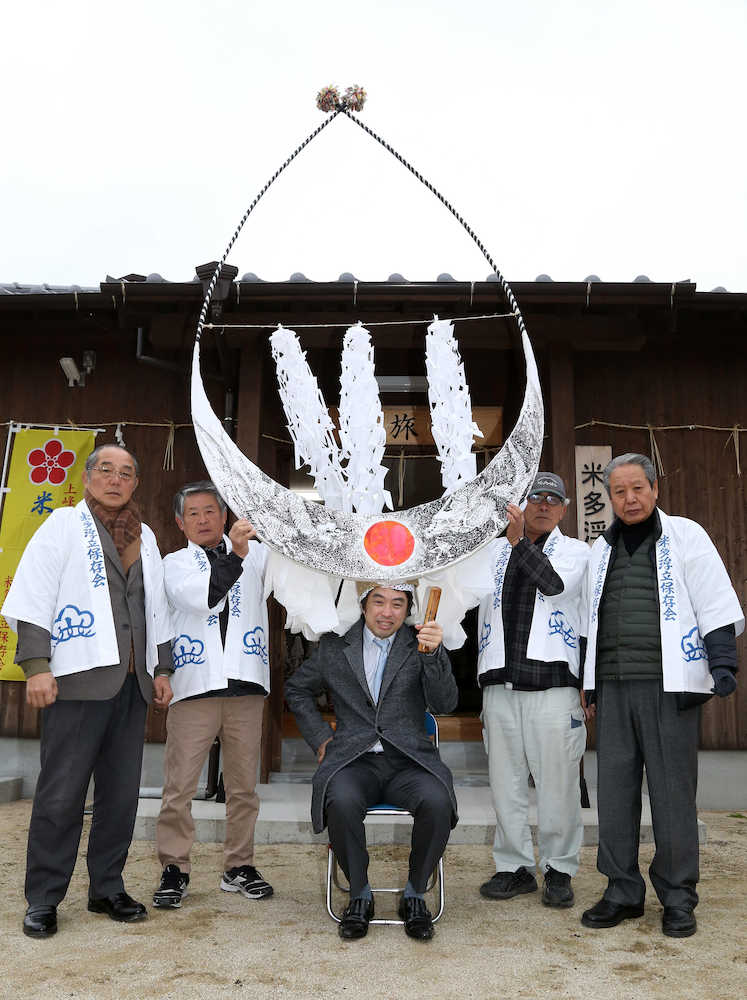 佐賀県重要無形民俗文化財の米多浮立で使われる、３メートルの天衝のかぶり気を引き締める久保王将（中央）