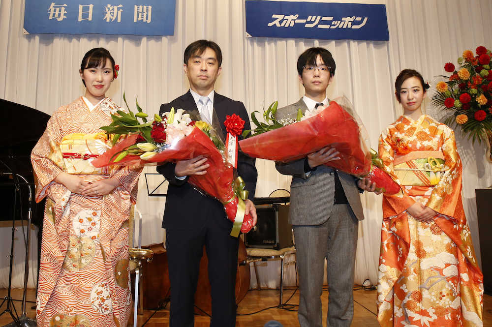 王将戦第４局前夜祭で花束を手に持つ久保王将（左から２人目）と豊島八段（同３人目）