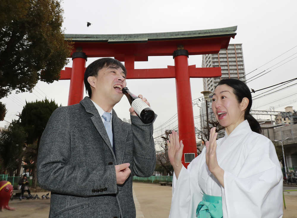 尼崎えびす神社で大はまのポン酢を飲む久保王将（左）にびっくりする太田垣宮司