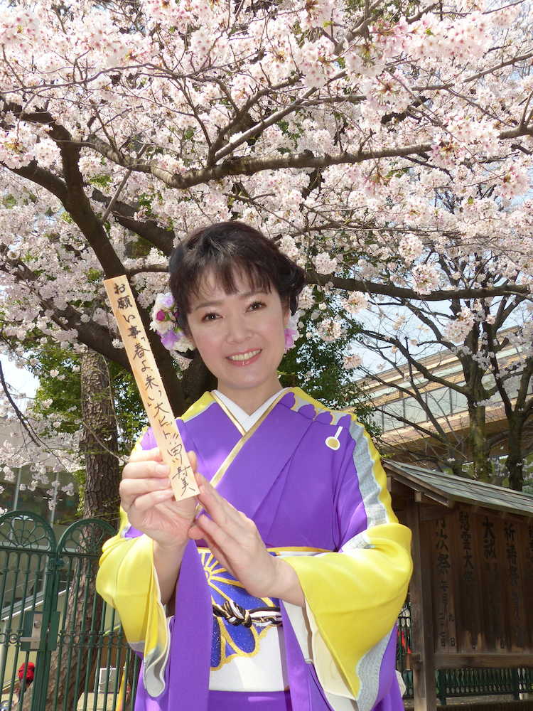 満開の桜をバックに新曲のヒットを祈願する田川寿美