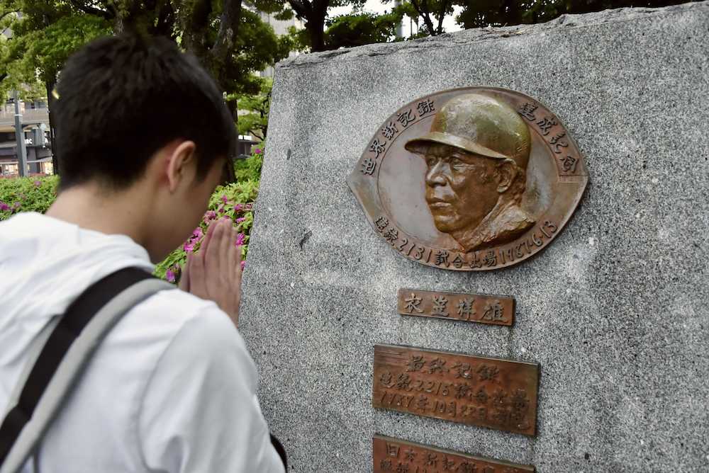 連続試合出場の世界新記録達成を記念した衣笠祥雄氏の碑。帰宅途中の男性が手を合わせていた＝２４日夕、広島市