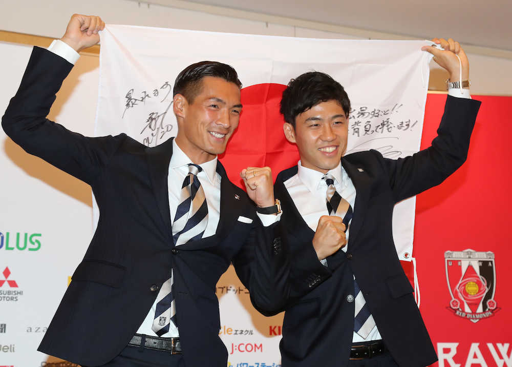 浦和からＷ杯日本代表に選出された槙野（左）、遠藤は意気込みを書いた日の丸を手にガッツポーズする（撮影・沢田　明徳）