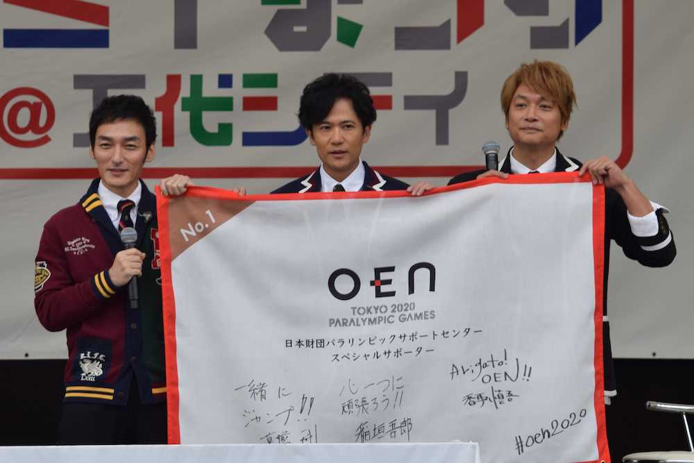 ２０２０年東京パラリンピックを支援するフラッグにメッセージを書き込んで掲げる（左から）草なぎ剛、稲垣吾郎、香取慎吾