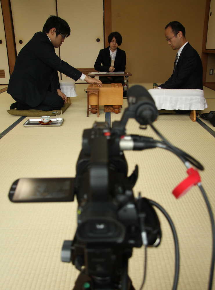 第６８期王将戦挑戦者決定リーグ戦プレーオフで初手を指す糸谷哲郎八段（左）。中継カメラが静かに見守る