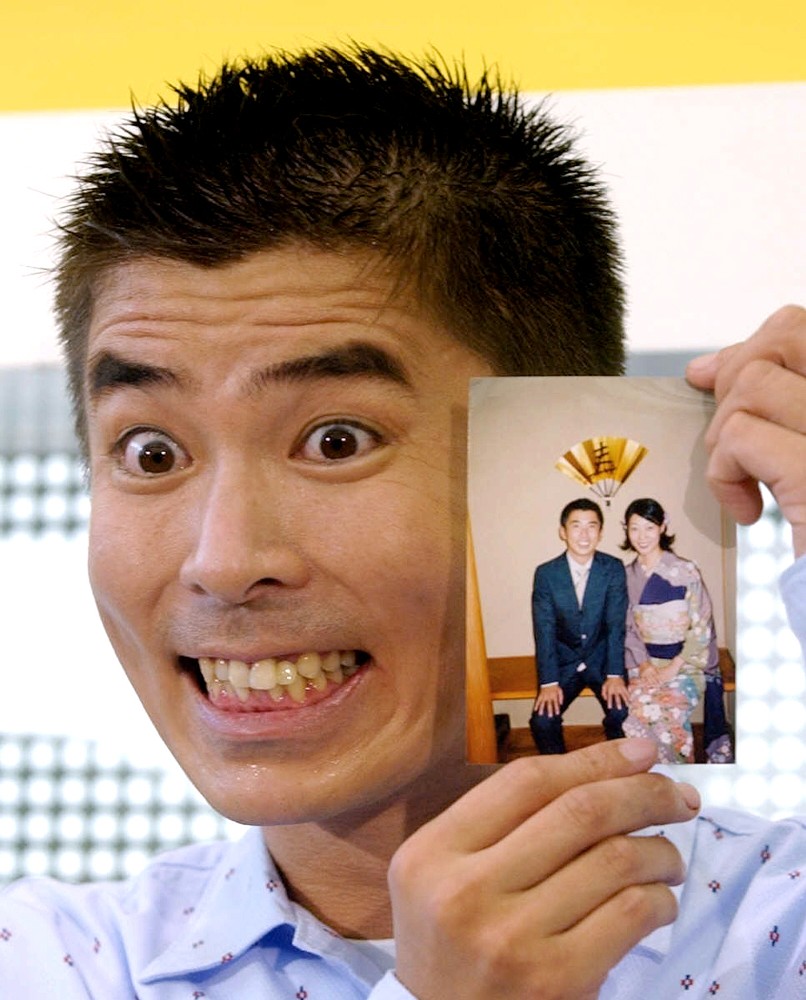 入籍会見で、おどけた表情で妻・澄子さんとの記念写真を見せる勝俣州和（２００２年）