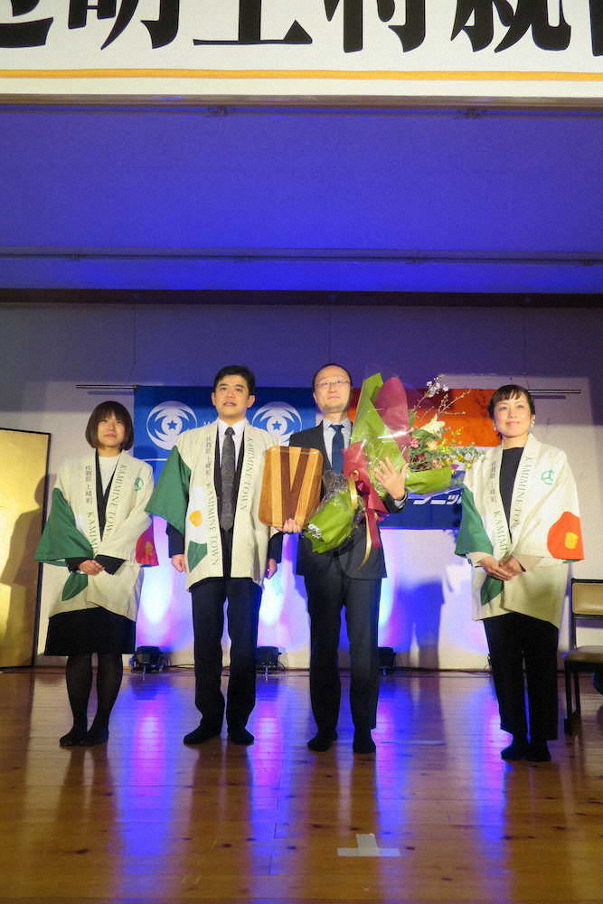 贈呈された花束を持ち武広勇平上峰町長（左から2番目）らと記念撮影をする渡辺明二冠