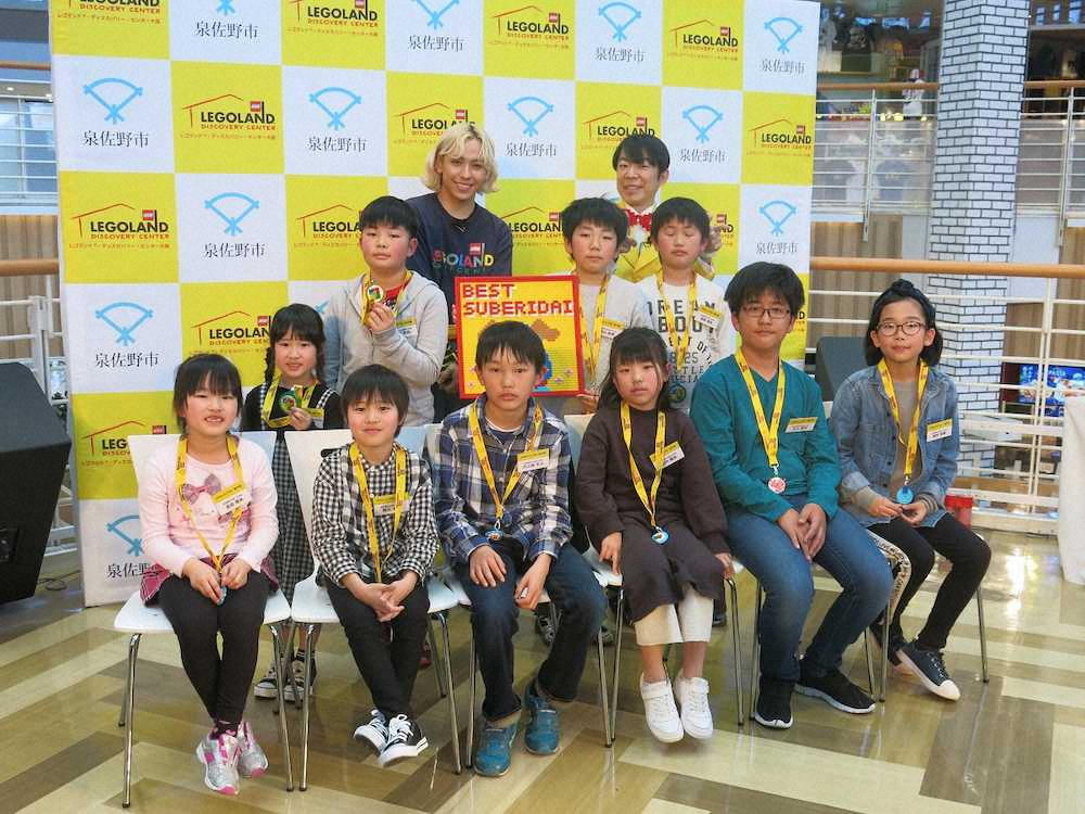 「オモロい滑り台選手権」の表彰式に出席したりゅうちぇる（後列左）、ダンディ坂野（同右）と入賞した小学生10人