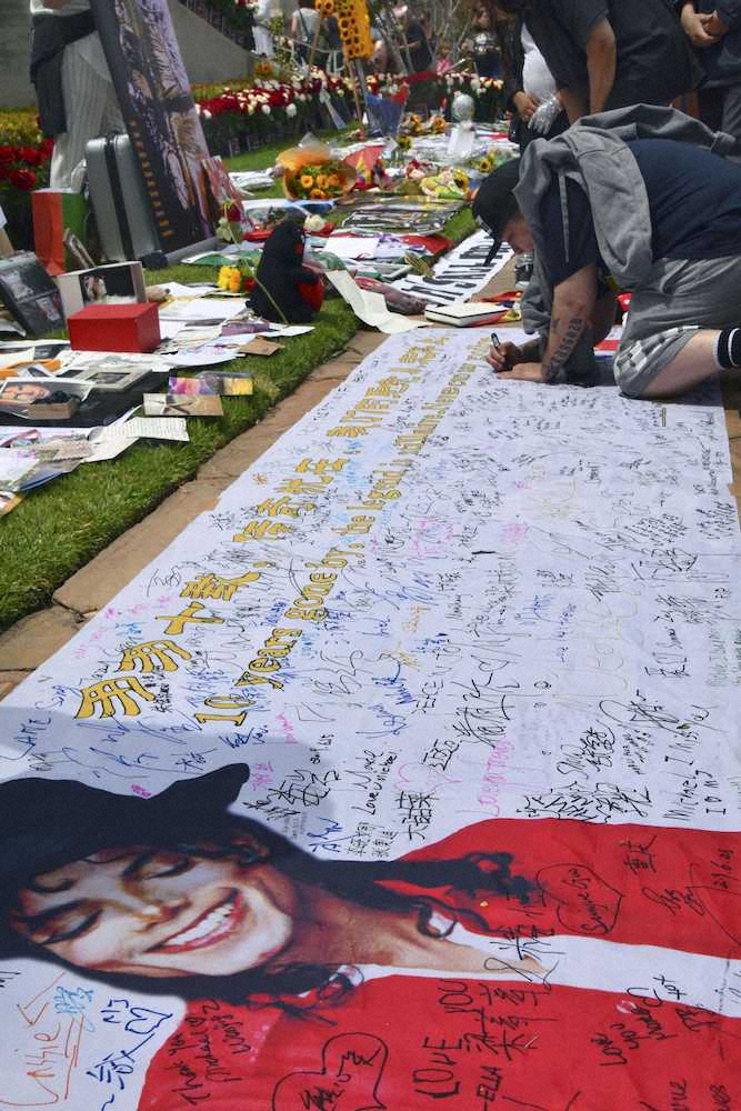 マイケル・ジャクソンさんを追悼し、横断幕にメッセージを書き込む男性