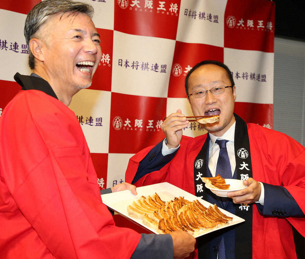 大阪王将・文野会長（左）から提供された餃子を食べる渡辺王将（撮影・荻原　浩人）