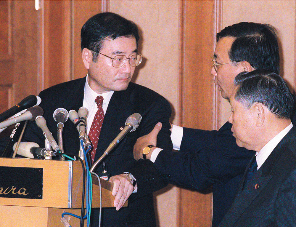 00年11月、「加藤の乱」で本会議に出席しようとする加藤氏（左）の腕を取って引き留める加藤派の谷垣氏