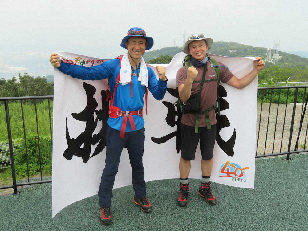 奈良・生駒山で練習登山を行ったABCの岩本計介アナ（左）と気象予報士の正木明氏はキリマンジャロ山頂へ持参する「挑戦」の横断幕を背負う