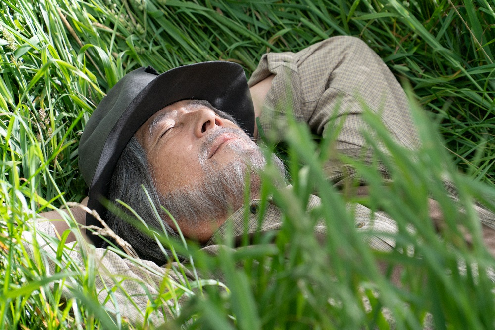 連続テレビ小説「なつぞら」最終回。草むらに寝転び、目を閉じる泰樹（草刈正雄）（C）NHK