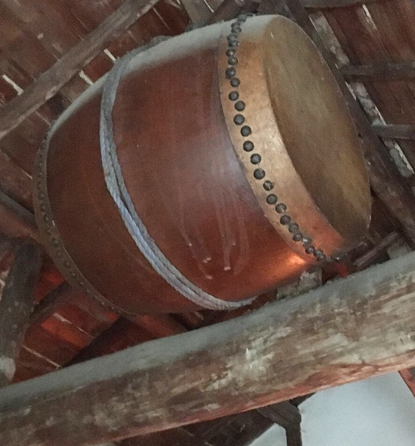 蔵の屋根からつるされた古い太鼓