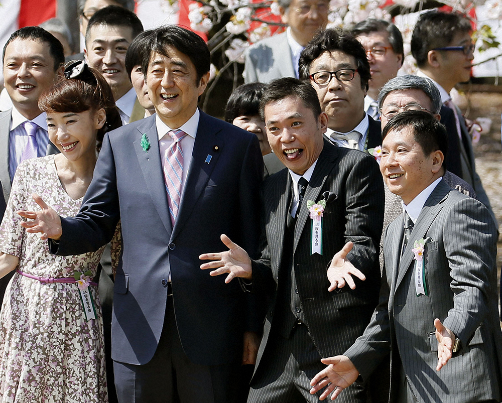 2015年4月、「桜を見る会」で「爆笑問題」（右）ら招待客と記念写真に納まる安倍首相