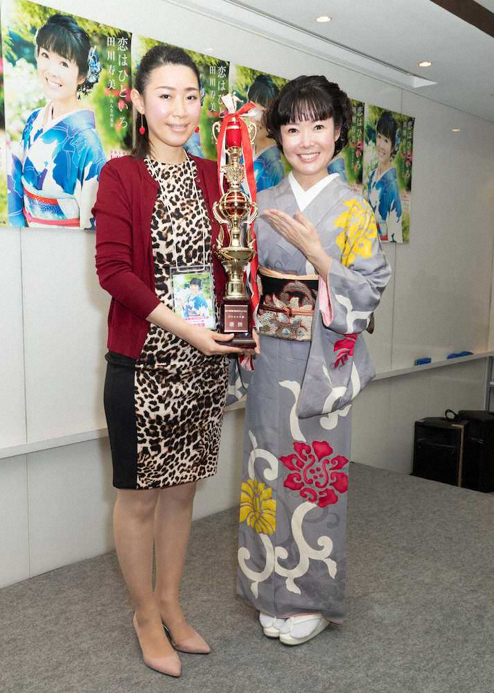 カラオケ決勝大会を開催した田川寿美（右）が優勝者とニッコリ