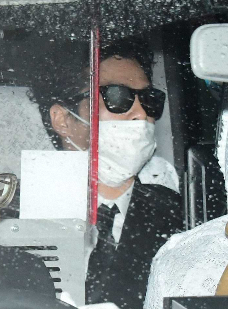 マスクとサングラスで顔を隠し、東京地裁に入る国母被告（撮影・岸　良祐）