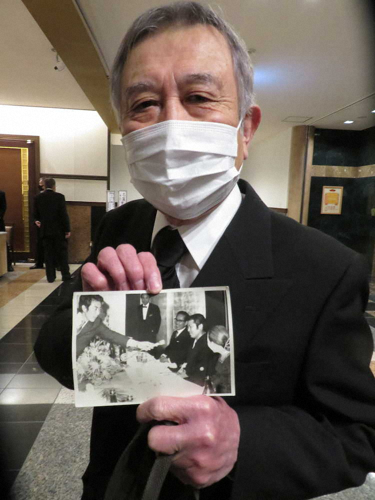 志賀勝さんの結婚式のメモリアルショット（写真の左が本人、右から2人目が志賀さん）を胸元に忍ばせ葬儀に訪れた「チャンバラトリオ」志茂山高也