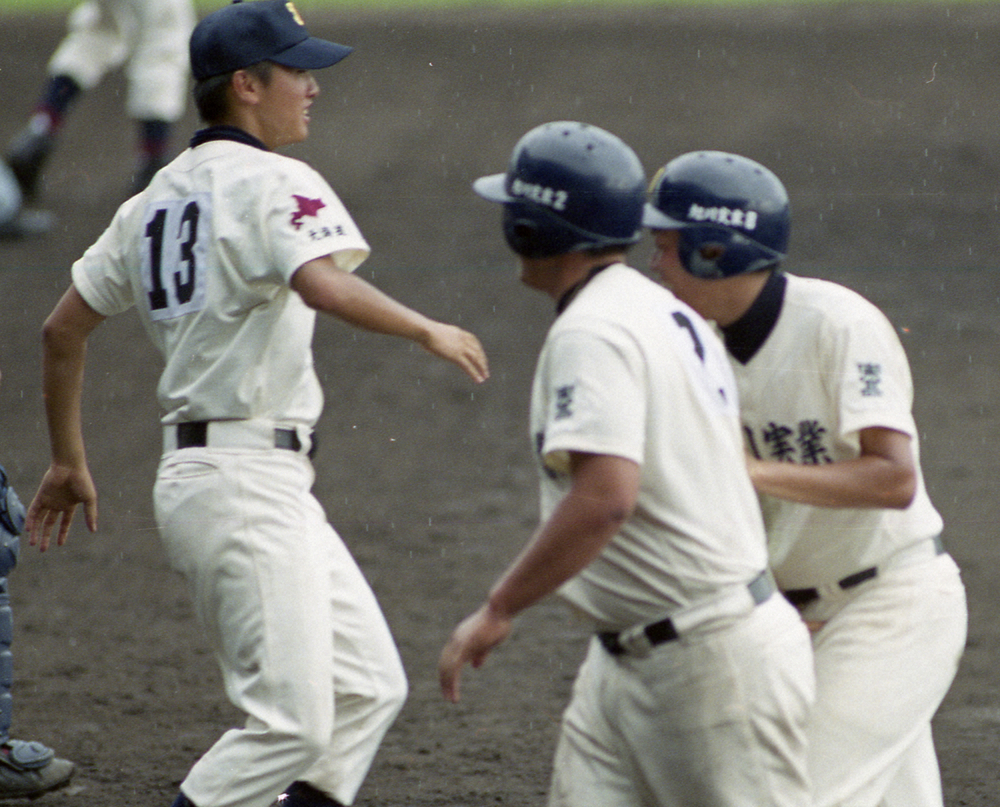 99年の夏、新潟明訓戦でグラウンドに立つ旭川実の安村（左）