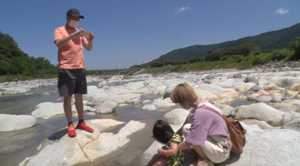 河原で遊ぶ妻・飯村貴子と愛娘をカメラに収めるいしだ壱成（C）TBS