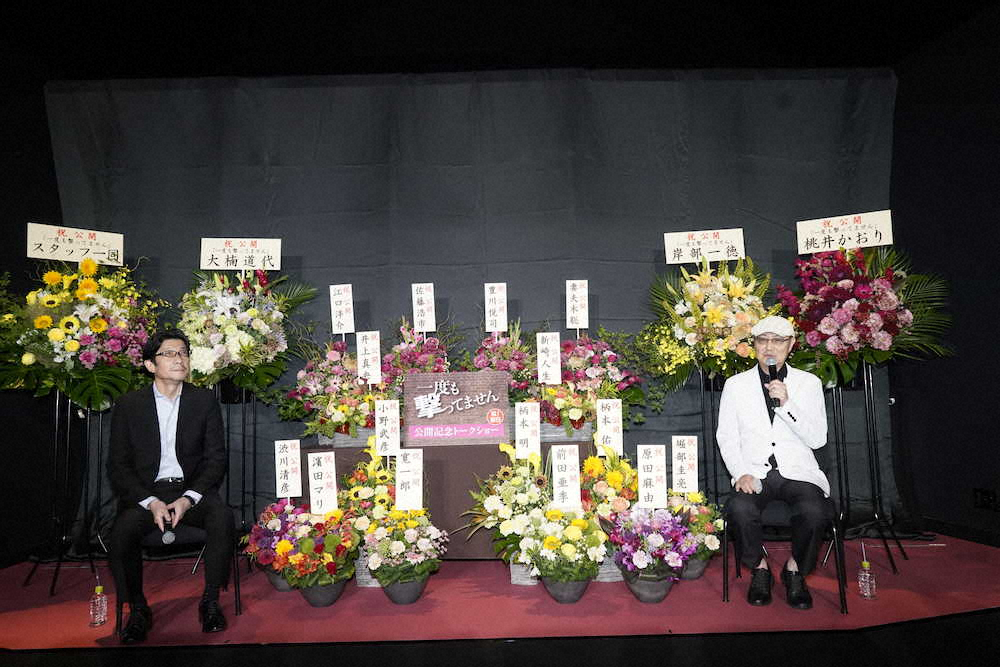 阪本順治監督（左）と試写会でトークショーを行った石橋蓮司。2人の間には共演者らの名前が入った花が置かれた