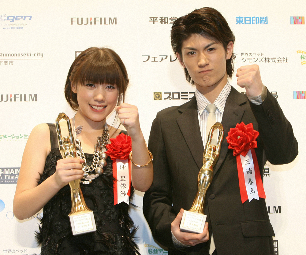 2009年2月、毎日映画コンクールでスポニチグランプリ新人賞を受賞しガッツポーズをする三浦春馬さん（右）。左は仲里依沙