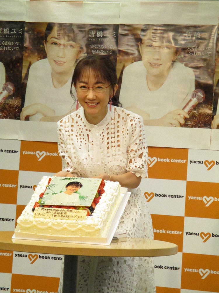新刊発売とデビュー曲世界配信の合同記者会見で、バースデーケーキを持ち笑顔を見せる唐橋ユミ
