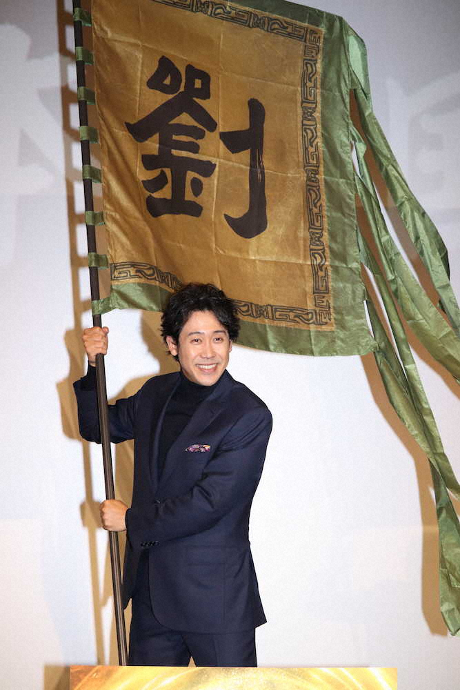 主演映画「新解釈・三國志」の大ヒット舞台あいさつで、撮影で使った劉備軍の旗を振る大泉洋