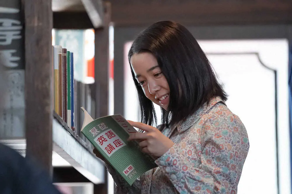 上白石萌音演じるヒロイン安子。書店でラジオ英語講座のテキストを見つけてにっこり