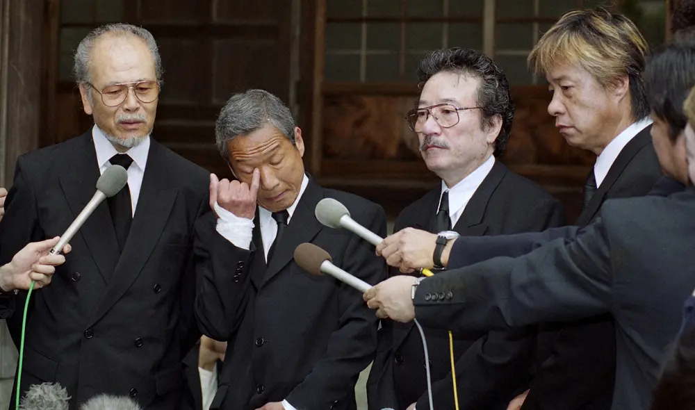 井上大輔さんの告別式で取材に応じる（左から）高橋健二さん、ジャッキー吉川さん、小田啓義、三原綱木（00年撮影）
