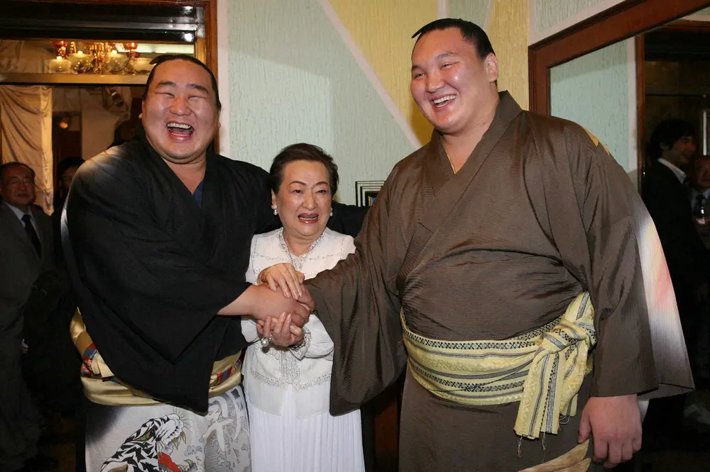 2008年、大相撲・モンゴル巡業。日本大使館主催のパーティーで朝青龍（左）と白鵬（右）と握手する細木さん
