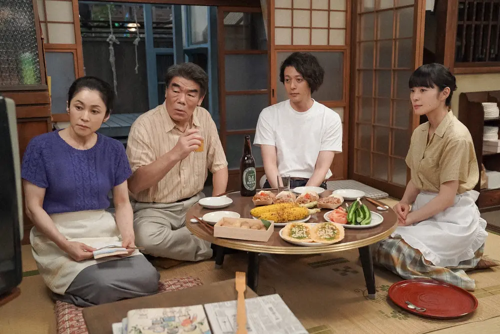 連続テレビ小説「カムカムエヴリバディ」第48話。竹村クリーニング店・茶の間にて。るいたちと晩ごはんを食べる錠一郎（オダギリジョー）。左から、和子（濱田マリ）、平助（村田雄浩）、るい（深津絵里）（C）NHK