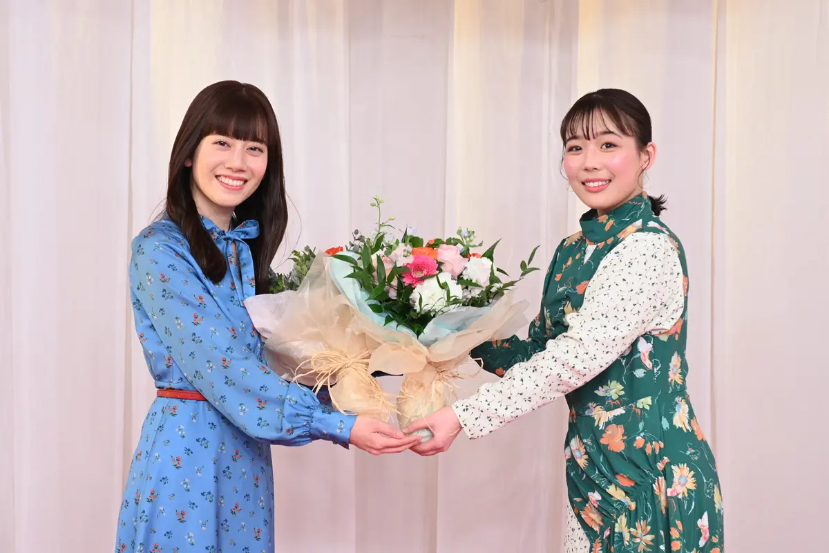 新「歌のお姉さん」ながたまや(右)から花束を贈呈される、4月2日卒業の「歌のお姉さん」小野あつこ