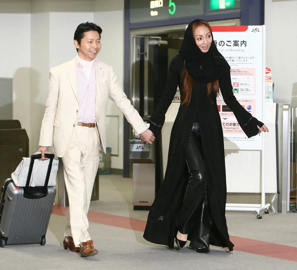 08年、新婚旅行を終えて、手をつなぎながら帰国した西村拓郎氏と民族衣装のアバヤを着る神田うの