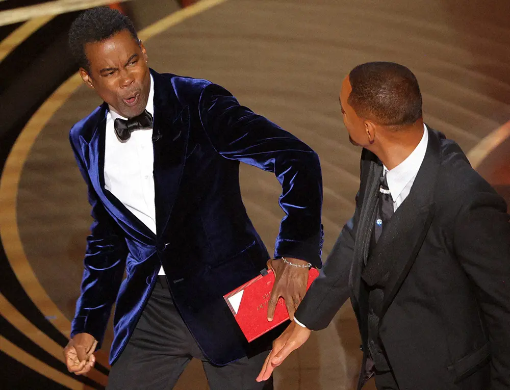 米アカデミー賞の授賞式でクリス・ロック（左）を殴るウィル・スミス（ロイター）