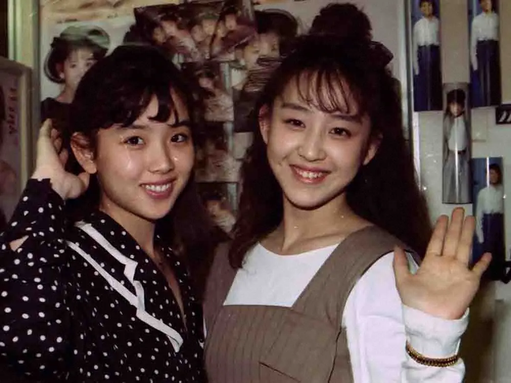 デビュー翌年の1989年、笑顔で手を振るWinkの相田翔子（右）と鈴木早智子