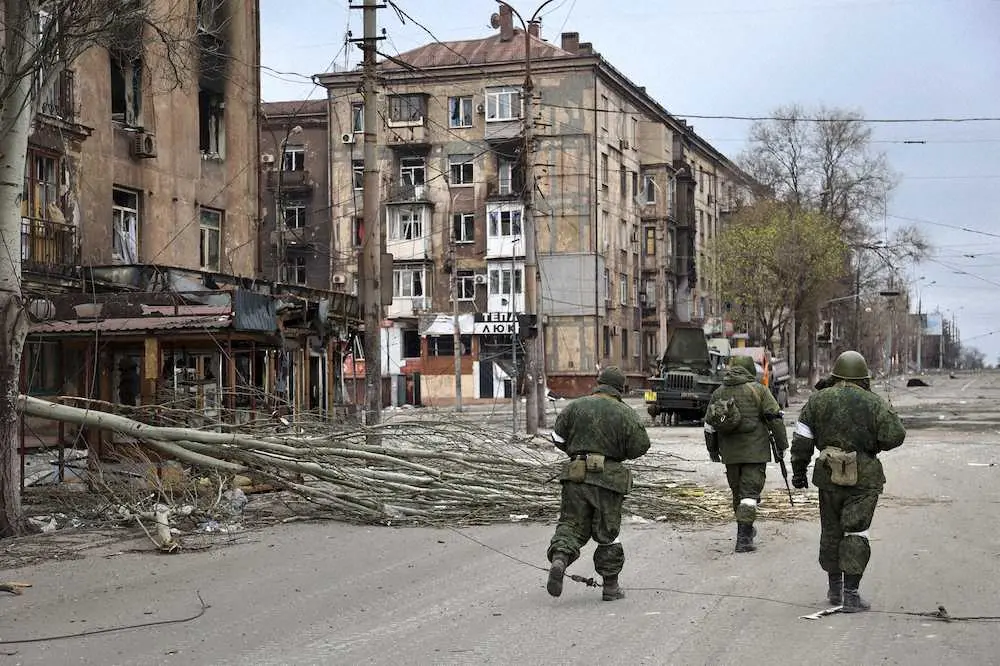 16日、ウクライナのマリウポリを歩く親ロシア派勢力の兵士ら（AP）