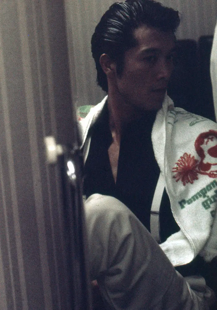 77年8月、初の日本武道館公演の本番前、楽屋でリーゼントをセットした矢沢永吉。肩に掛けたタオルは「E.YAZAWA」のデザインではなくスヌーピーの絵柄なのが印象的だ