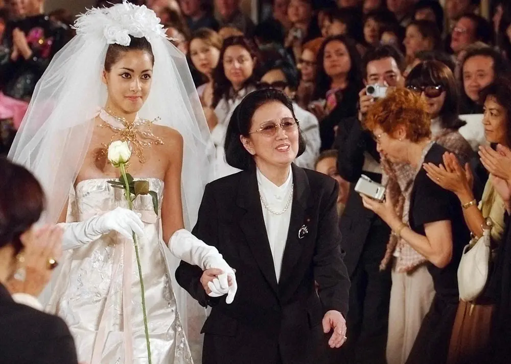 ウエディング姿の孫娘のモデル・森泉（左）の手をとって登場したファッションデザイナーの森英恵さん（AP）