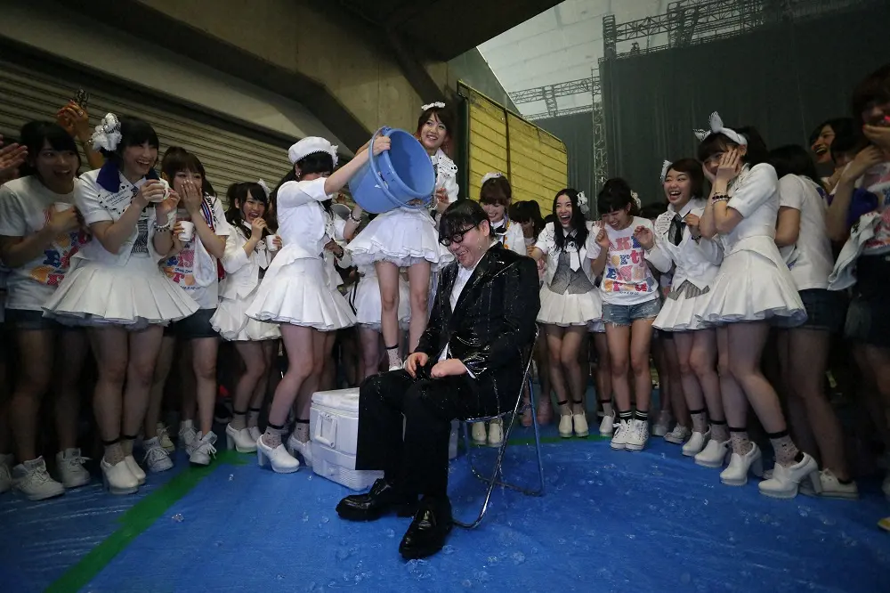 2014年、AKB48の高橋みなみ、渡辺麻友から「アイス・バケツ・チャレンジ」の一環で氷水を浴びせられた秋元康氏（中央）。悲鳴を上げるメンバーもビチョビチョ