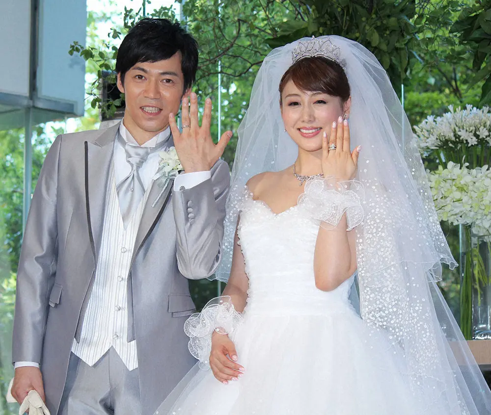 2012年7月、結婚披露会見で結婚指輪を披露する東貴博（左）と安めぐみ