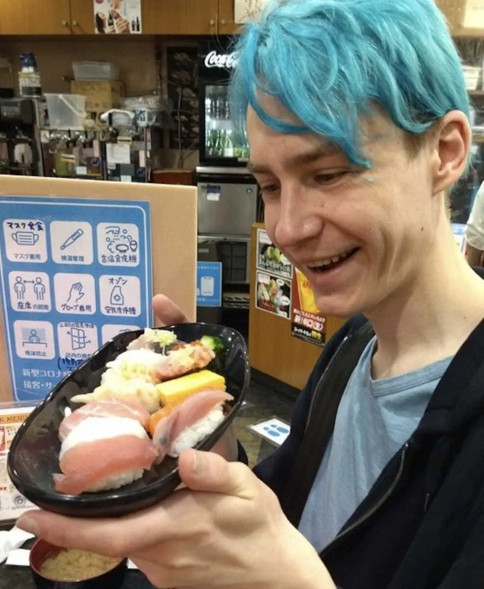 寿司を手に笑顔のアルトゥル・ガラタさん(本人提供)