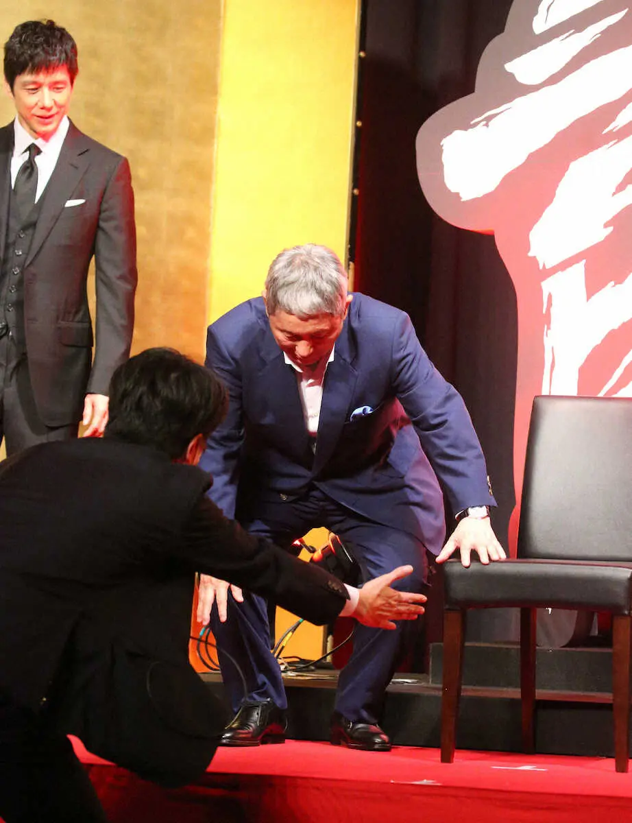 【画像・写真】北野武監督は記念撮影で椅子に座る場面であえて床に腰を下ろし笑いをとる（左は西島秀俊）＝撮影・西川　祐介