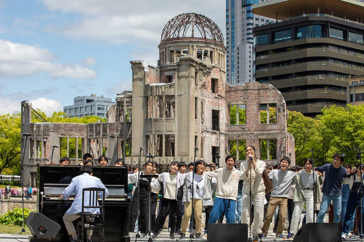 広島・平和記念公園前で学生とともにライブパフォーマンスを行い、歌唱するAI
