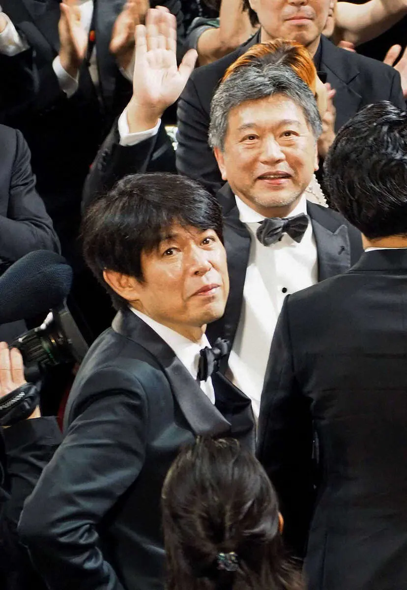 17日、カンヌ国際映画祭で「怪物」の公式上映後、客席に手を振る是枝裕和監督（上）と坂元裕二氏。坂元氏は脚本賞を受賞