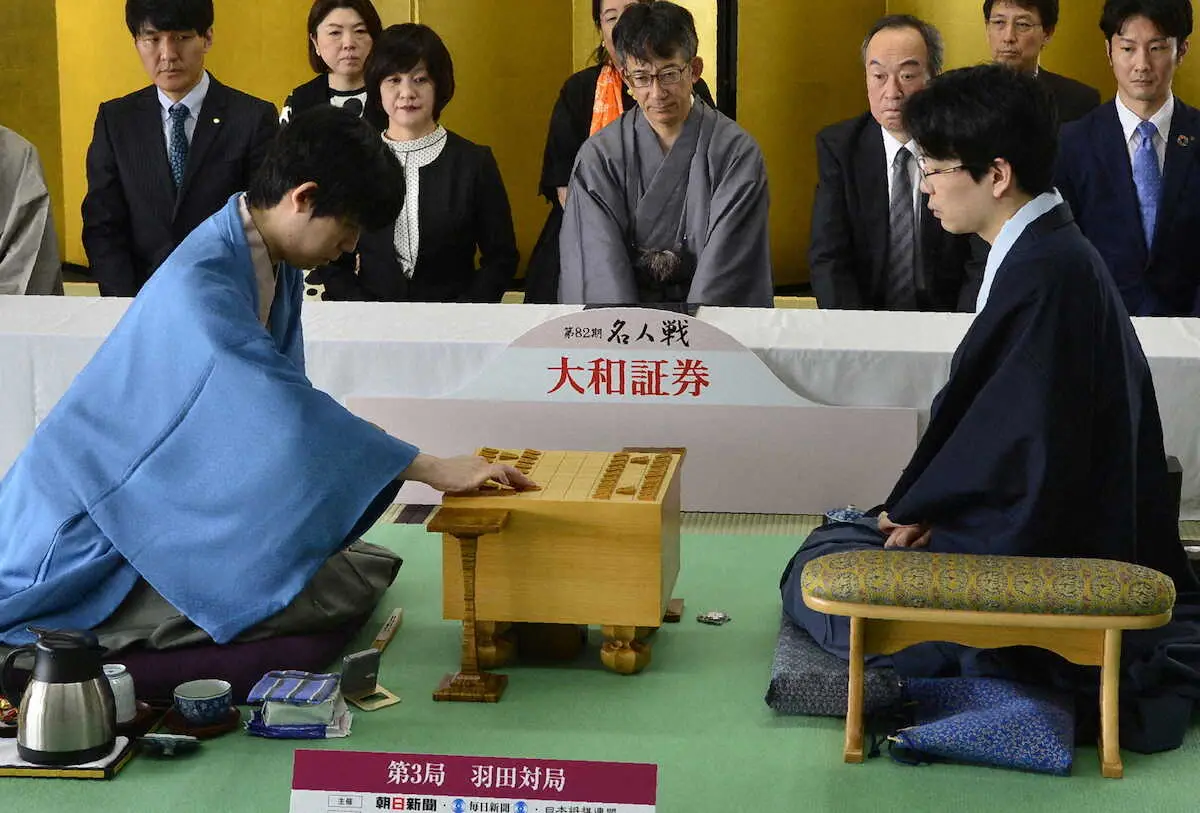 初手を指す藤井聡太名人（左）。右は豊島将之九段（日本将棋連盟提供）