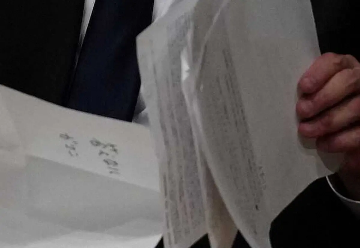 【画像・写真】「答えない　ガマン」とメモ書きされた紙を手にする遠藤副会長