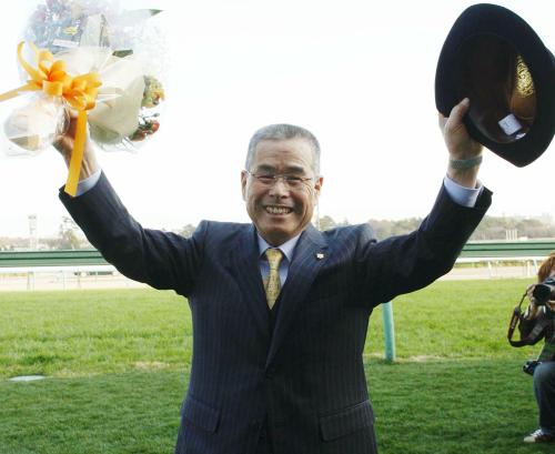 定年による引退を迎え、花束を手にファンに別れを告げる池江泰郎調教師