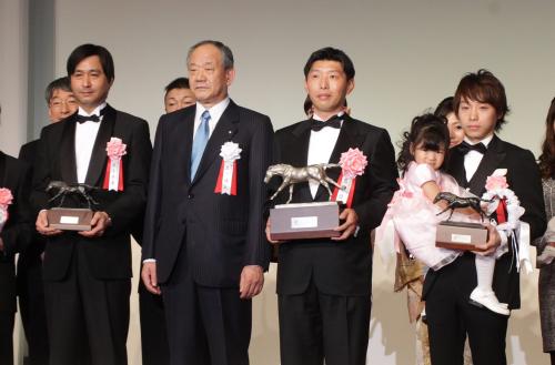 オルフェーヴルが年度代表馬を受賞して表彰される（左から）池江師、土川理事長、吉田代表、娘の心菜ちゃんを抱く池添